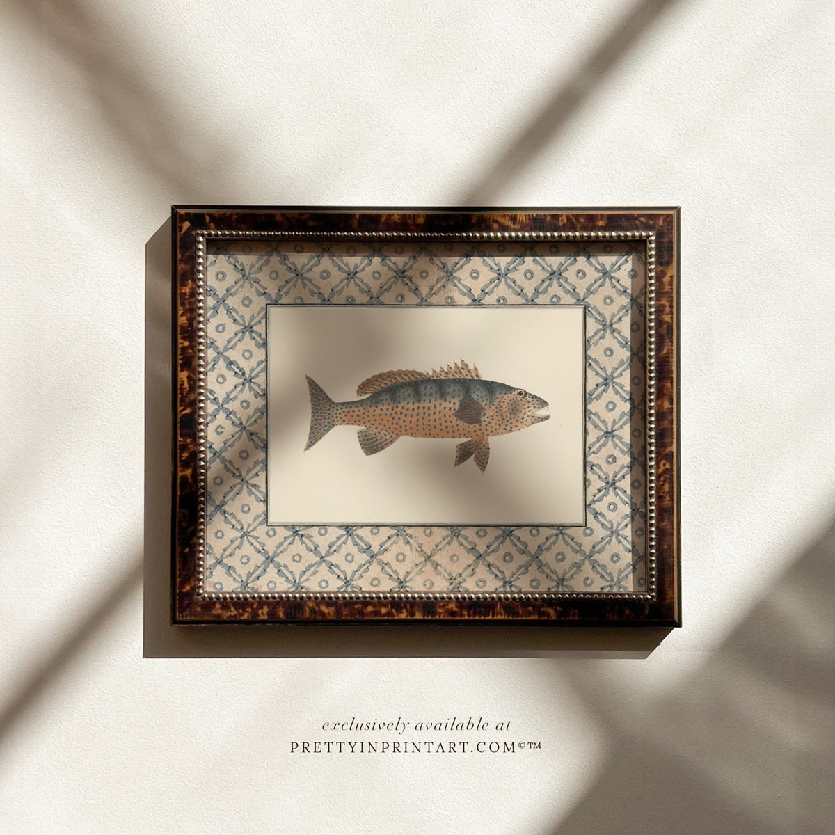 Vintage spotted amber and slate fish art print with a blue lattice border in a tortoiseshell-style wooden frame, ideal for a coastal bathroom or cottage kitchen