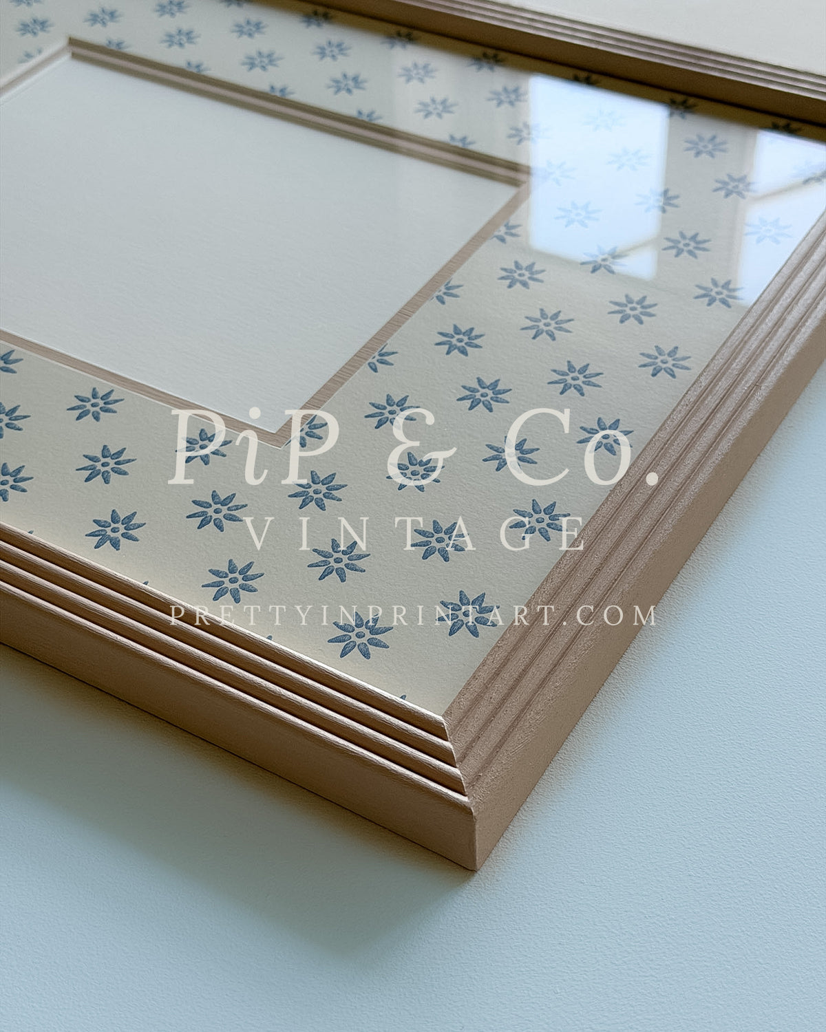 Hand painted reeded picture frame in Farrow and Ball Setting Plaster with Borastapeter Skogsstjarna wallpaper mount.