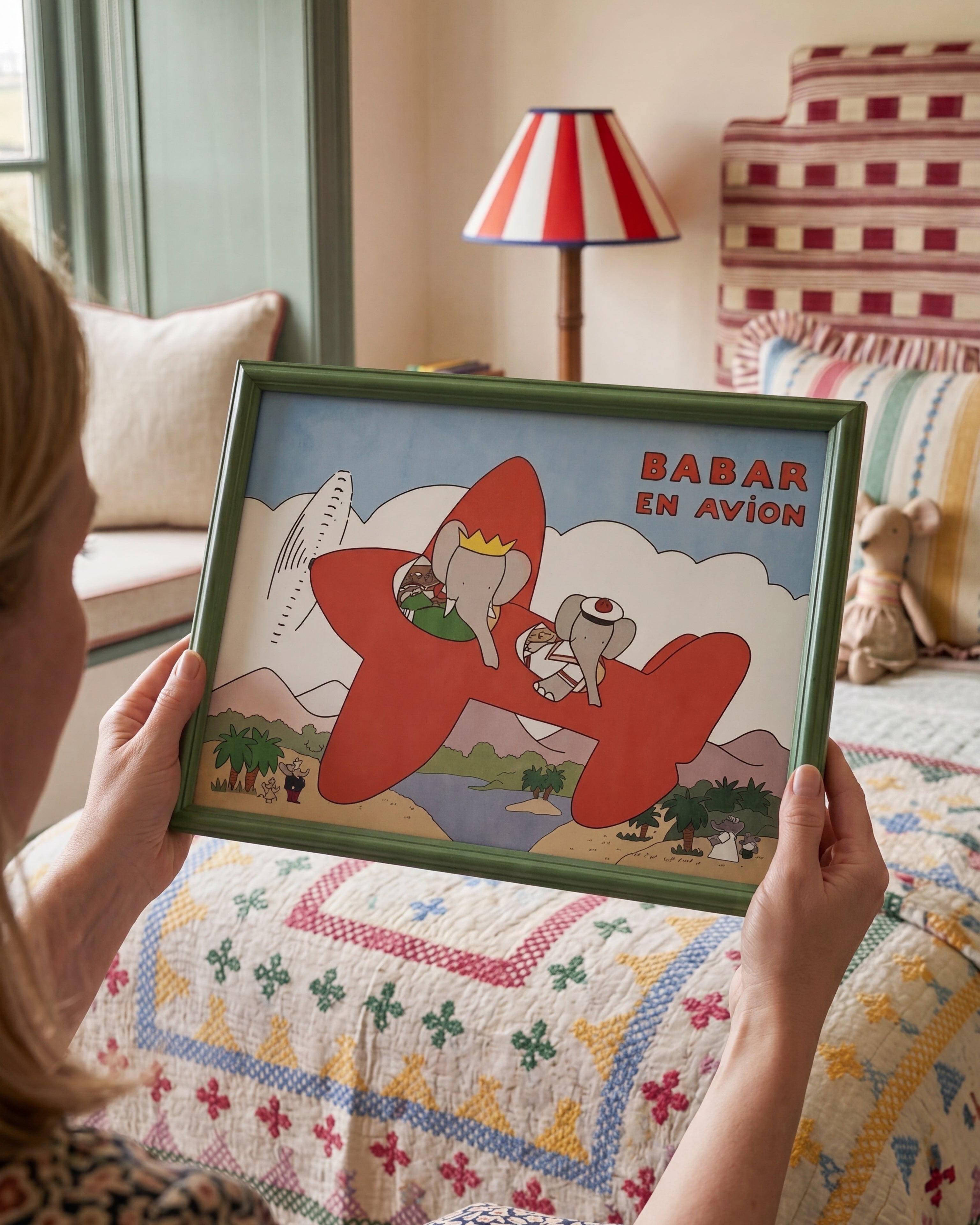 Gender-neutral nursery decor, unisex baby wall art, "Grandmillennial" nursery. Woman holding Babar nursery art print in green frame