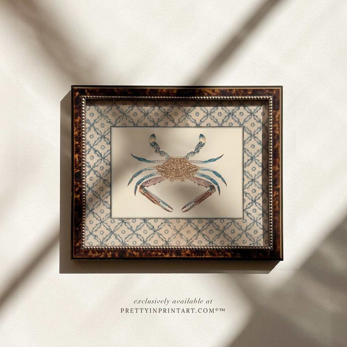 Vintage blue crab art print with a blue lattice border in a tortoiseshell-style wooden frame, ideal for a coastal bathroom or cottage kitchen