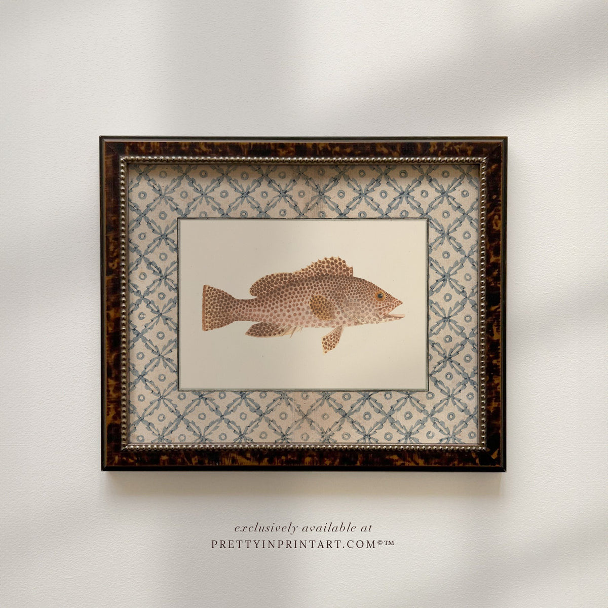 Vintage speckled brown fish art print with a blue lattice border in a tortoiseshell-style wooden frame, front view