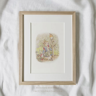 vintage Beatrix Potter nursery art print featuring Peter Rabbit in ornate gold picture frame, perfect for classic baby room decor