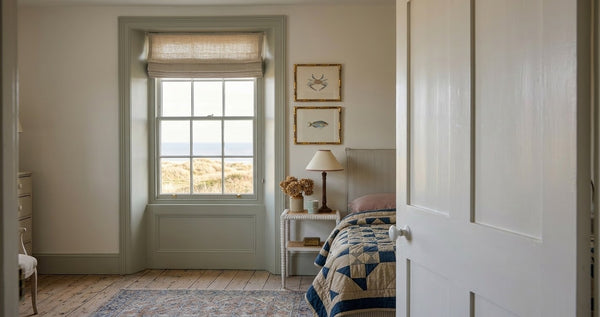 Vintage crab and fish prints in gold bamboo frames in a seaside bedroom